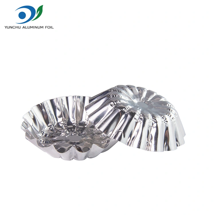 A tojás tortákat egy levegő sütő ezüst alumínium fólia ételtartályban sütjük A tojás tortákat egy levegő sütő ezüst alumínium fólia ételtartályban sütjük